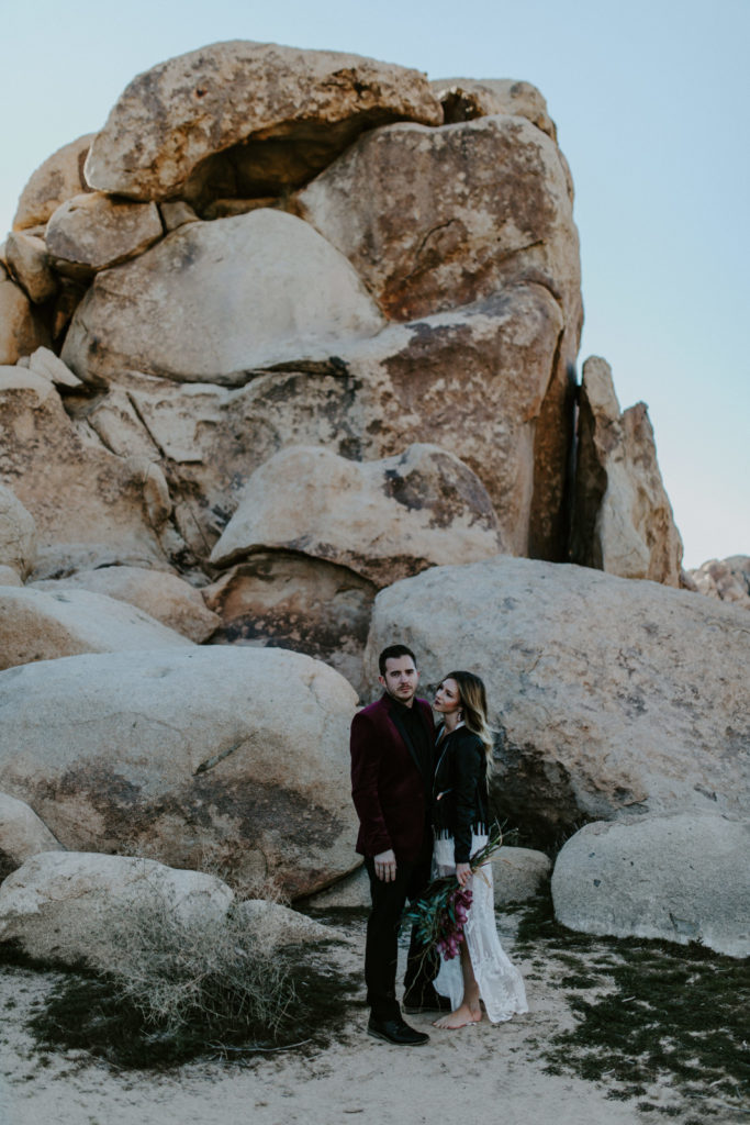 Alyssa and Jeremy stand near the rocks in Joshua Tree National Park.