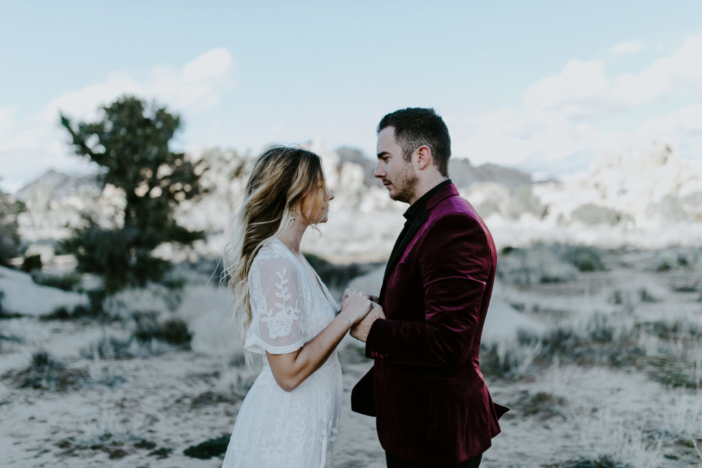 Alyssa and Jeremy stand together holding hands during their elopement ceremony in Joshua Tree National Park.