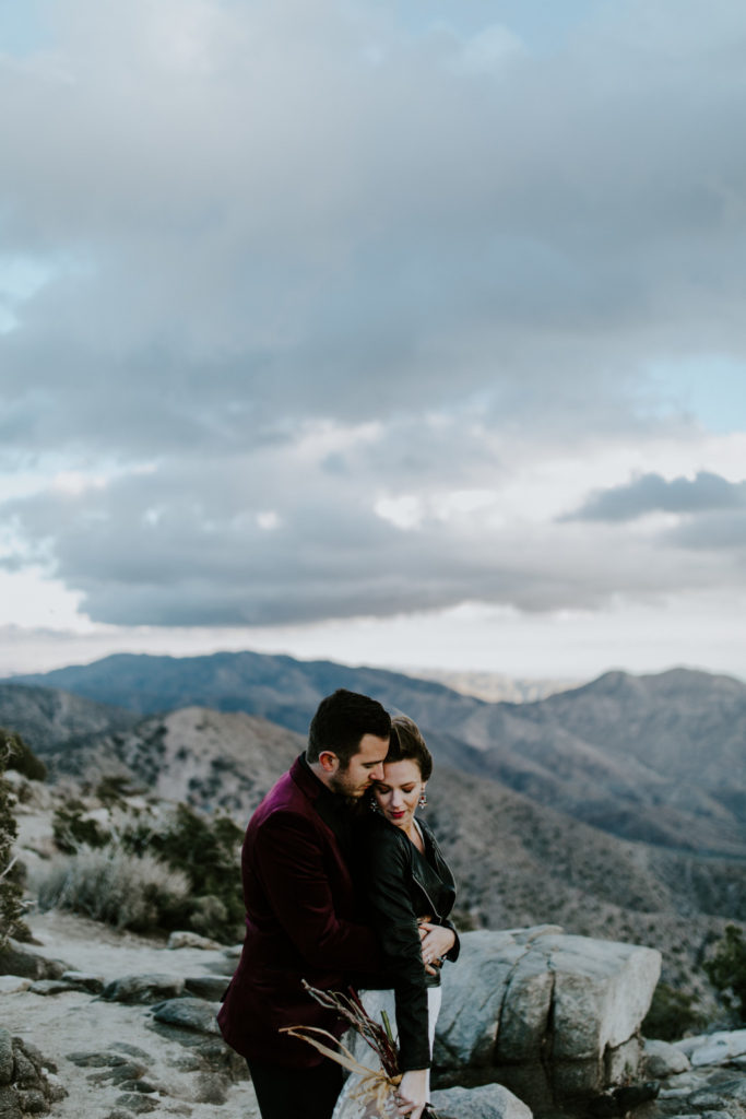 Alyssa and Jeremy stand under the clouds in Joshua Tree National Park.