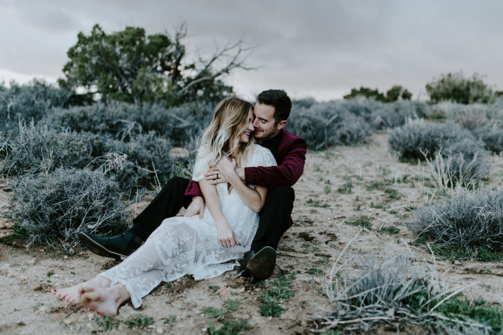 Alyssa and Jeremy sit in the sand of Joshua Tree National Park.